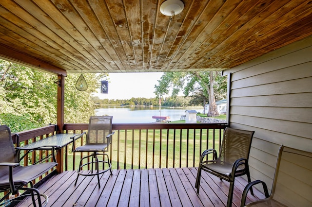 wooden deck with a lawn and a water view