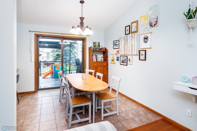 dining area with light tile patterned flooring, an inviting chandelier, and lofted ceiling