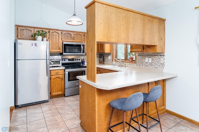 kitchen featuring tasteful backsplash, stainless steel appliances, light tile patterned floors, kitchen peninsula, and decorative light fixtures