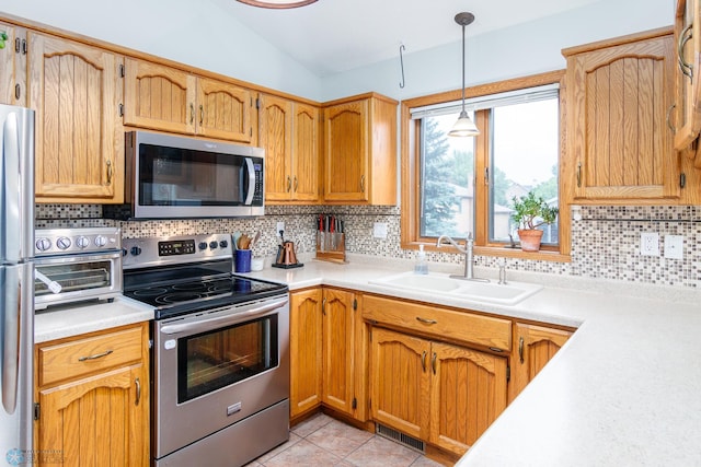 kitchen featuring decorative backsplash, appliances with stainless steel finishes, pendant lighting, and sink