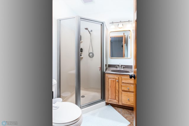 bathroom featuring tile patterned floors, walk in shower, vanity, and toilet