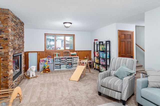 sitting room featuring carpet flooring, a fireplace, and a textured ceiling