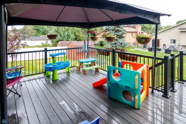 wooden terrace with a lawn and a gazebo