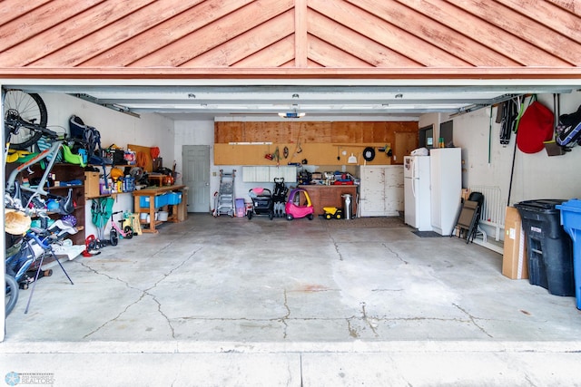 garage featuring a workshop area and white fridge