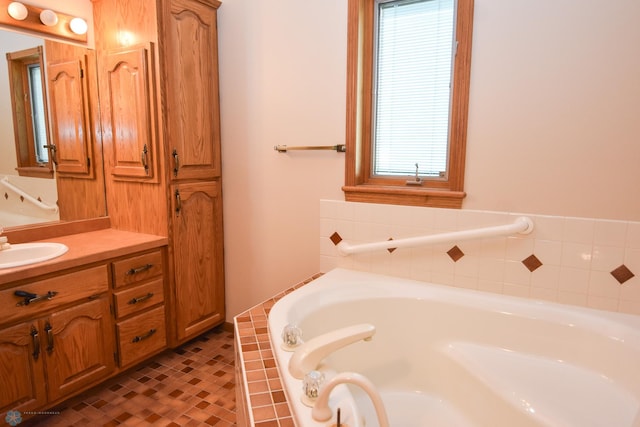 bathroom with a wealth of natural light, tile patterned floors, tiled tub, and vanity