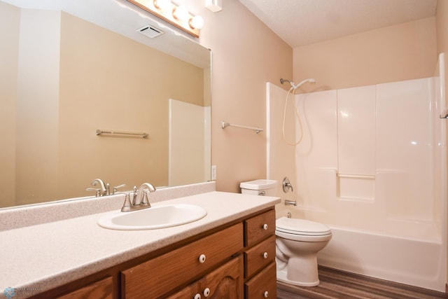 full bathroom featuring bathtub / shower combination, vanity, hardwood / wood-style floors, and toilet