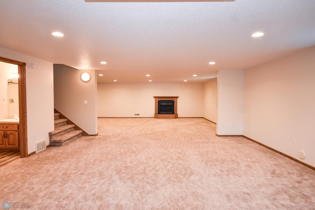 basement with a textured ceiling and light carpet