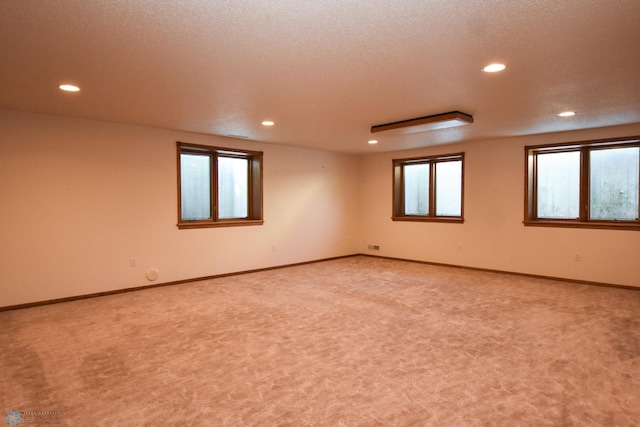 carpeted empty room with a textured ceiling