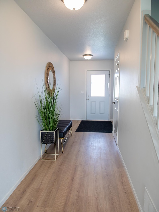 interior space featuring light wood-type flooring and a textured ceiling