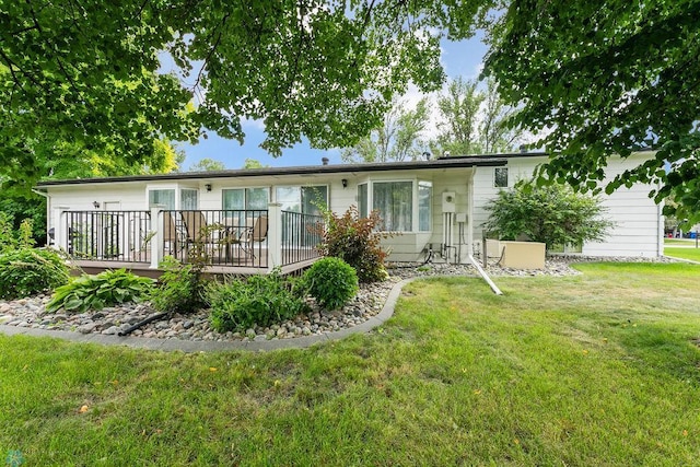 back of house featuring a wooden deck and a lawn