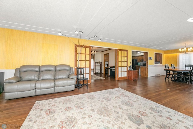 living room with dark wood-type flooring and a chandelier