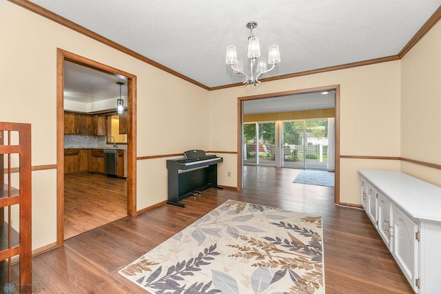 interior space with sink, crown molding, an inviting chandelier, and dark hardwood / wood-style floors