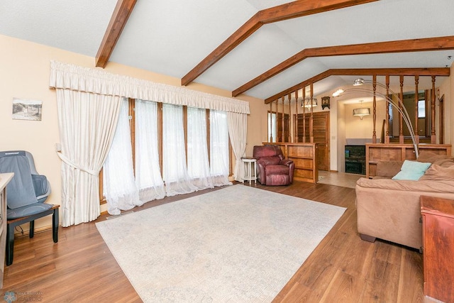 living room featuring hardwood / wood-style floors and vaulted ceiling with beams