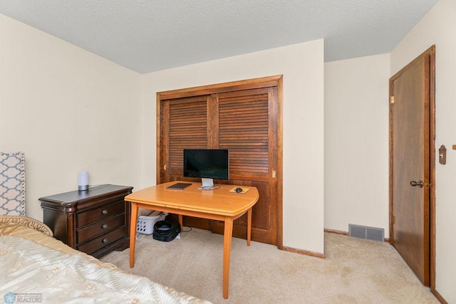 bedroom featuring a textured ceiling and light carpet