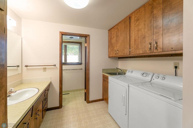 clothes washing area with sink, light tile patterned flooring, and washer and dryer