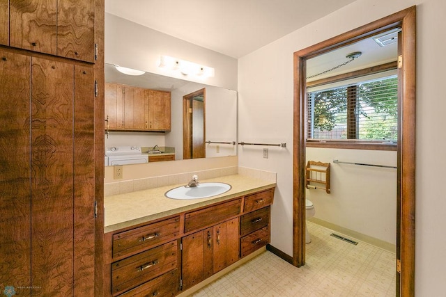 bathroom with toilet, vanity, and tile patterned floors