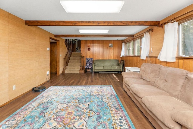 living room with wood walls, dark hardwood / wood-style flooring, and beamed ceiling