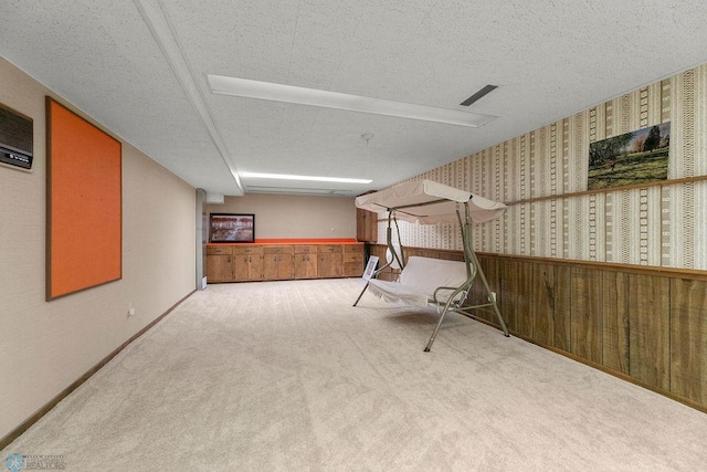 basement featuring a textured ceiling and carpet floors