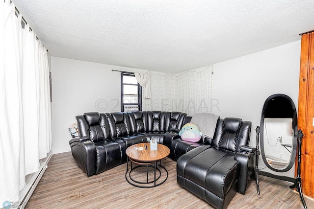 living room with a baseboard heating unit, a textured ceiling, and light hardwood / wood-style floors