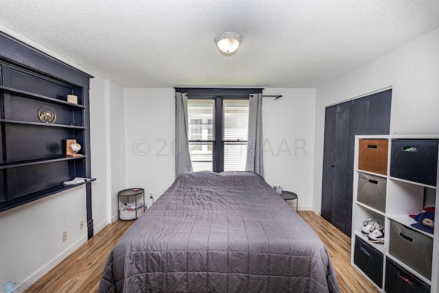 bedroom featuring a textured ceiling and light wood-type flooring