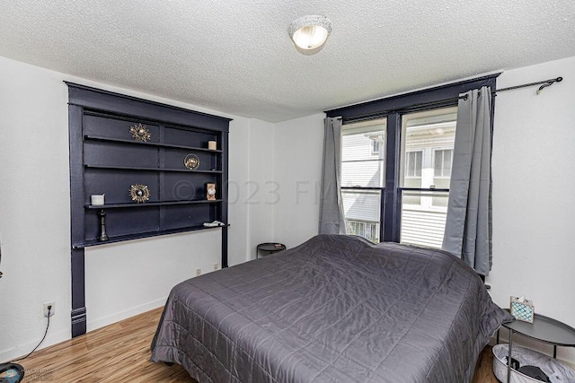 bedroom with a textured ceiling and hardwood / wood-style floors