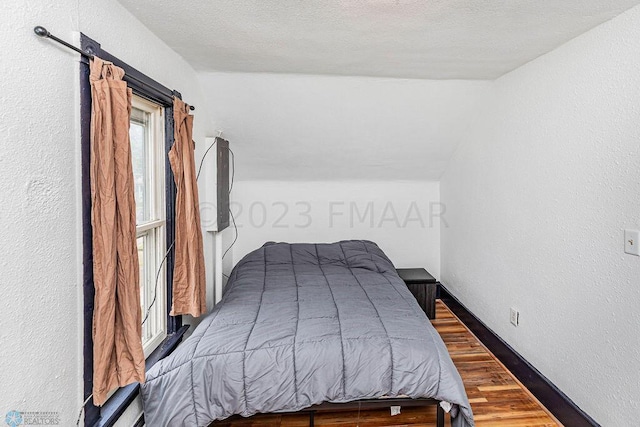 bedroom with dark wood-type flooring and a textured ceiling