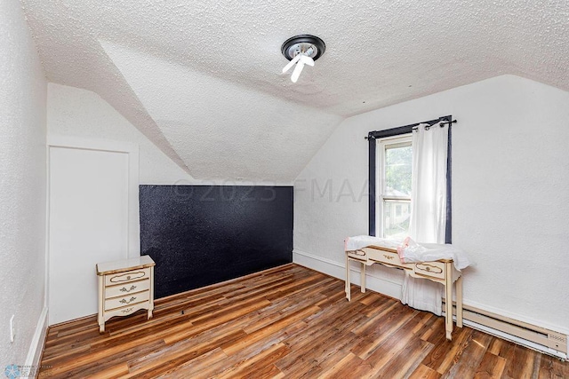 bonus room with a textured ceiling, hardwood / wood-style floors, and vaulted ceiling