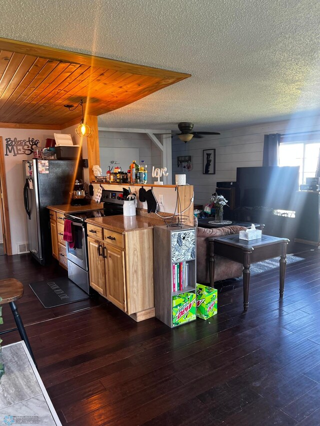 kitchen with ceiling fan, a textured ceiling, appliances with stainless steel finishes, light brown cabinetry, and dark hardwood / wood-style flooring