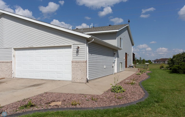 view of side of property with a lawn and a garage