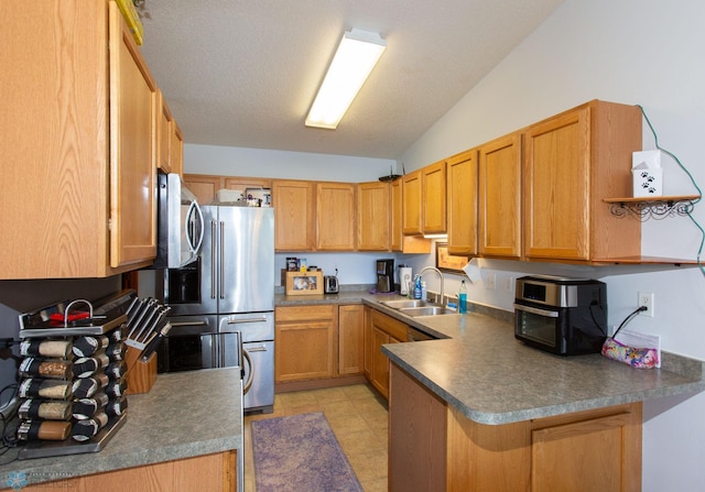 kitchen with vaulted ceiling, light tile patterned flooring, kitchen peninsula, a textured ceiling, and sink