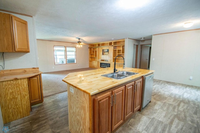 kitchen with dishwasher, sink, an island with sink, carpet flooring, and ceiling fan