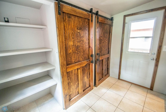 interior space featuring light tile patterned flooring and a barn door