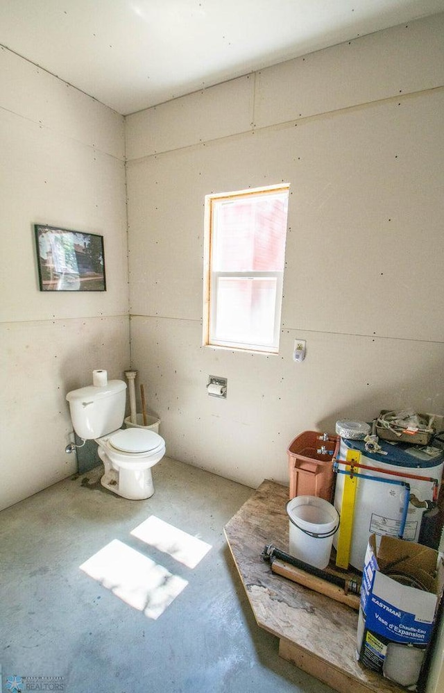 bathroom with concrete flooring and toilet