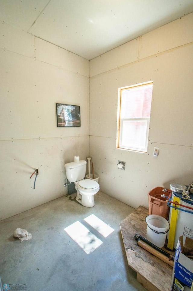 bathroom with concrete flooring and toilet