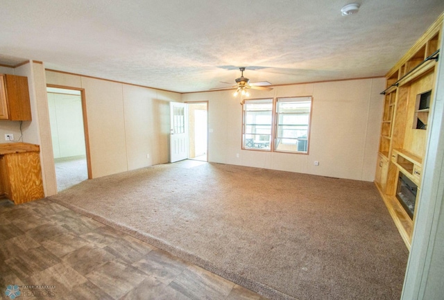 unfurnished living room with ceiling fan, a textured ceiling, and carpet flooring