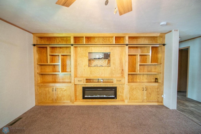 unfurnished living room with ceiling fan, dark carpet, and a fireplace