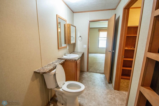 bathroom with tile patterned flooring, toilet, a textured ceiling, and vanity