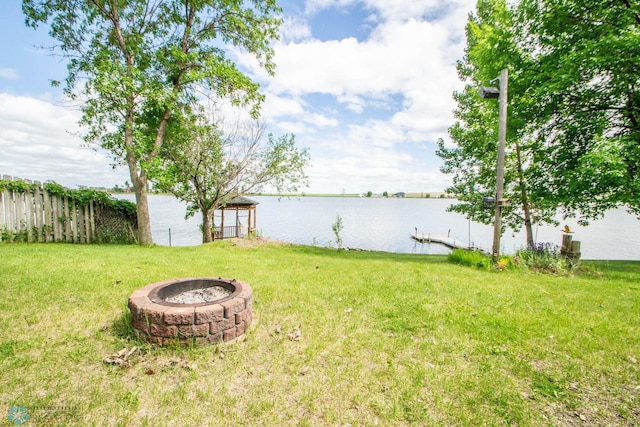 view of yard with an outdoor fire pit and a water view