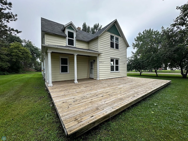 back of property with a yard and a wooden deck