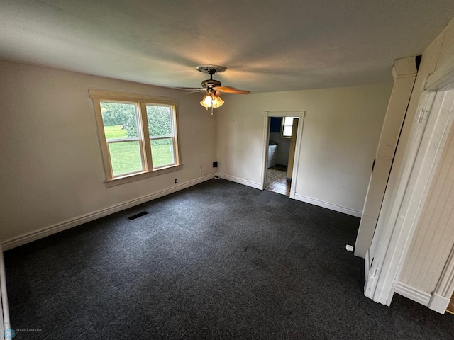 unfurnished bedroom with dark colored carpet and ceiling fan