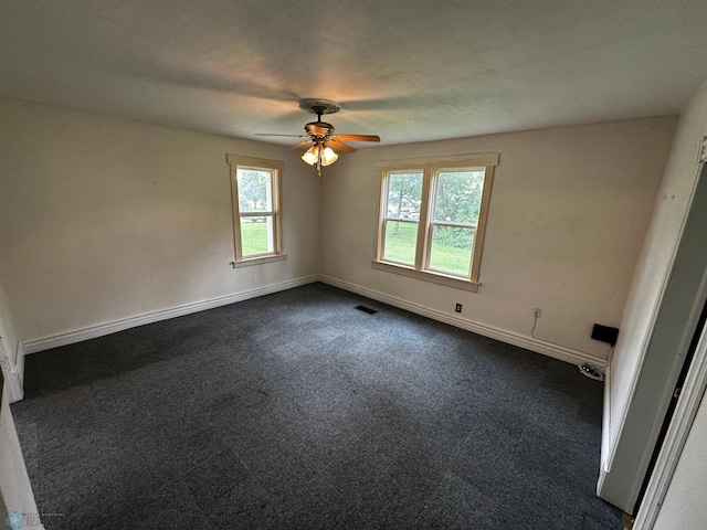 unfurnished room featuring plenty of natural light, ceiling fan, and carpet flooring