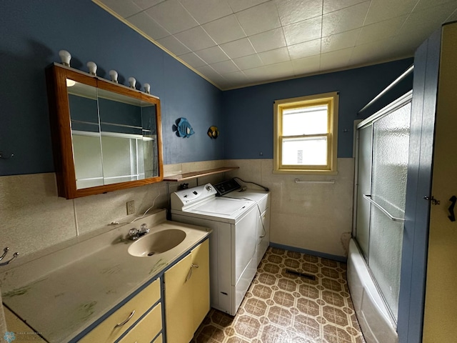 clothes washing area featuring sink, light tile patterned floors, and washer and clothes dryer