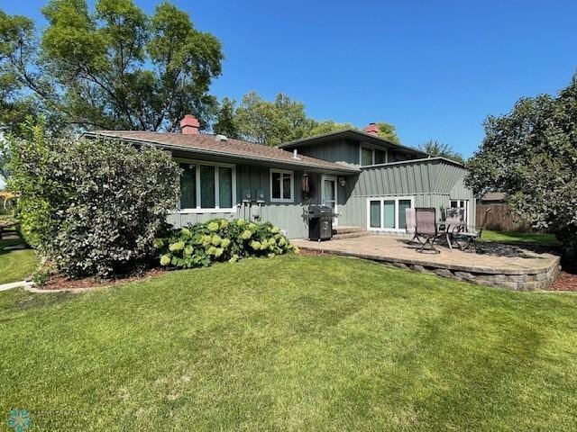 back of house with a patio and a yard