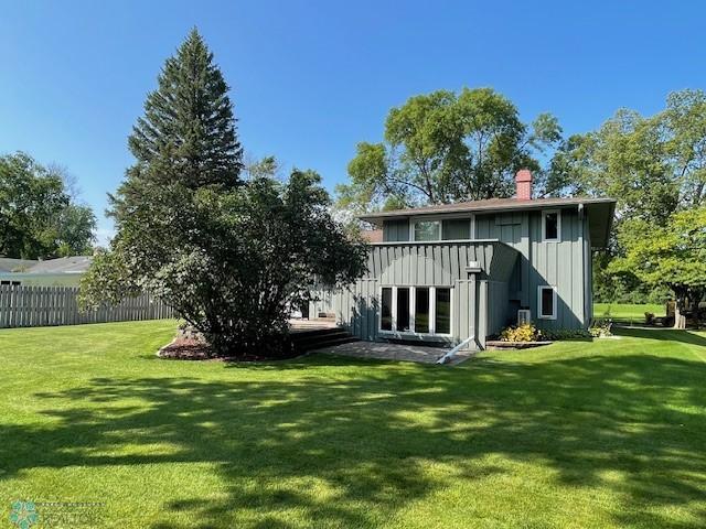 rear view of house featuring a yard