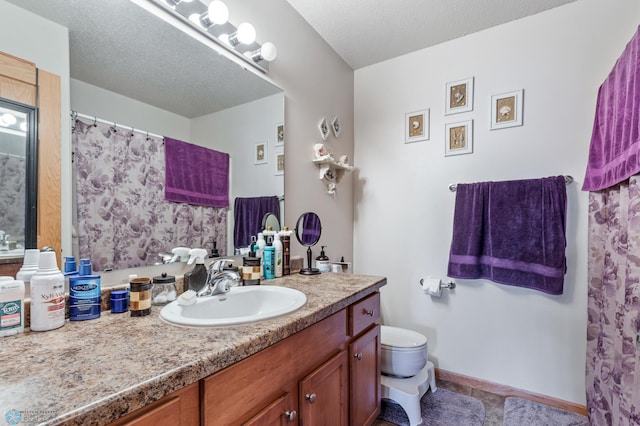 bathroom featuring tile patterned floors, toilet, a textured ceiling, and vanity