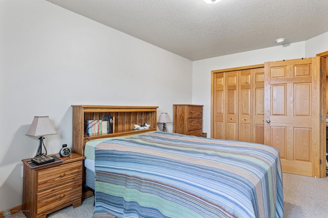 bedroom featuring light carpet, a closet, and a textured ceiling