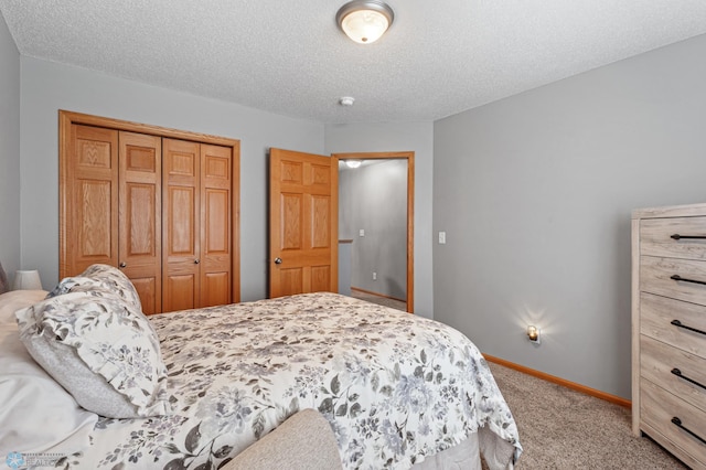 bedroom featuring a textured ceiling, a closet, and light carpet