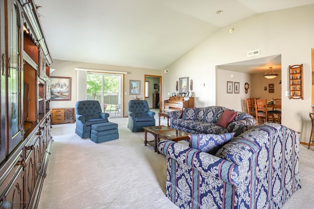 carpeted living room with high vaulted ceiling