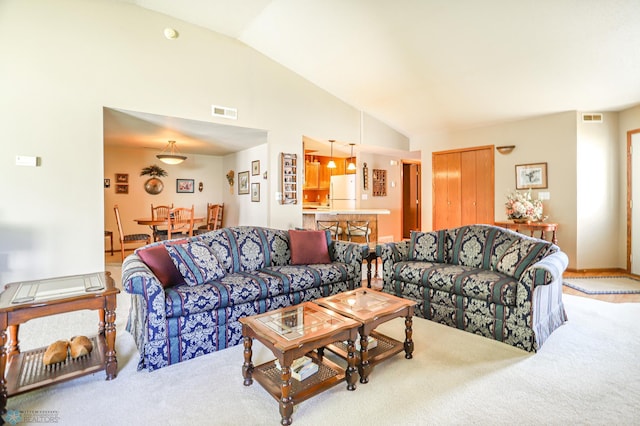 living room with carpet floors and high vaulted ceiling