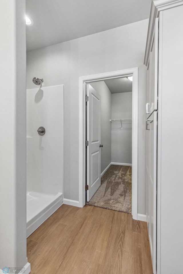 bathroom with hardwood / wood-style flooring and a shower